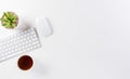 Flat lay, top view office table desk. Workspace with keyboard, mouse, green leaf, and coffee cup with copy space on white Royalty Free Stock Photo