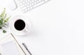 Flat lay, top view office table desk. Workspace with keyboard, office supplies, pencil, green leaf, and coffee cup with copy space Royalty Free Stock Photo