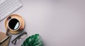 Flat lay, top view office table desk. Workspace with keyboard, office supplies, pencil, green leaf, and coffee cup on gray Royalty Free Stock Photo