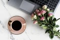 Flat lay, top view office table feminine desk. workspace with laptop, cup of cofee and bouquet pink roses.Mother`s day, birthday