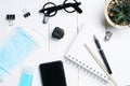 Flat lay, top view office white table wooden desk. Workspace with blank eyeglasses, diary, mask, alcohol gel and smartphone on Royalty Free Stock Photo