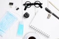 Flat lay, top view office white table wooden desk. Workspace with blank eyeglasses, diary, mask, alcohol gel and smartphone on Royalty Free Stock Photo