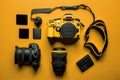 Flat lay or top view of photographer workplace with dslr camera, lens, pen tablet and camera accessories with yellow background. Royalty Free Stock Photo