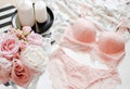 Flat lay. Top view pink lace lingerie. Beauty blog. Bouquet of roses and pions, parfume, jewelry, coffee on white bed background