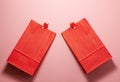 Flat lay top view of red paper gift bags with little tweezers with hearts on them on the bottom. Holidays presents and Valentines Royalty Free Stock Photo