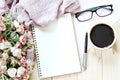Flat lay or top view of scarf, open blank notebook paper, coffee cup and eyeglasses on wooden background