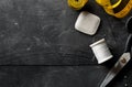 Flat lay top view sewing tools with measurement tape, chalk, thread and scissors on black dark wood table Royalty Free Stock Photo