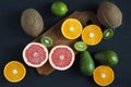 Flat lay. Top view. Sliced colorful fresh fruits: kiwi, orange, grapefruit and mandarin on wooden board.