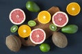 Flat lay. Top view. Sliced colorful fresh fruits: kiwi, orange, grapefruit and mandarin on wooden board. Coconuts, lime and avoca