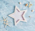 Flat lay top view Summer vacation mockup: star shaped photo frame, seashells and white starfish on blue background. Travel, beach Royalty Free Stock Photo