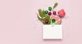 Flat lay top view White gift bag holographic glitter confetti red green christmas balls pine branches gift boxes on pink