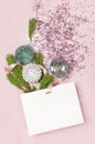 Flat lay top view White gift bag holographic glitter confetti Vintage Christmas New Year balls green pine branches on pink Royalty Free Stock Photo