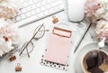 Flat lay top view women`s office desk with flowers. Female workspace with laptop, flowers peonies, accessories, notebook, glasses