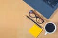 Flat lay, Top view work space in office. with laptop, Glasses, pencil, white coffee cup, office supplies on wooden Table.