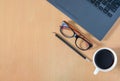 Flat lay, Top view work space in office.  with laptop, Glasses, pencil, white coffee cup on wooden Table. Royalty Free Stock Photo