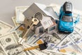 flat lay toy car, toy house, keys with remote control alarm and money on the table Royalty Free Stock Photo