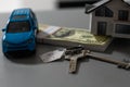 flat lay toy car, toy house, keys with remote control alarm and money on the table Royalty Free Stock Photo