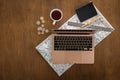 Flat lay, travel planning, laptop and map on a wooden table.