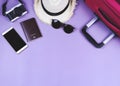 Flat lay of traveler accessories , passport , hat , mobile phone, camera,sunglasses and pink suitcase on purple background. travel Royalty Free Stock Photo