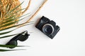 Flat lay traveler accessories on white background with palm leaf, vintage camera, woven rattan straw bag and sunglasses. Top view Royalty Free Stock Photo