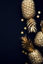 Flat lay tropical gold pineapple and confetti on a dark background