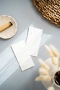 Flat lay of two blank cards sheet on aesthetic pastel grey background with plants and palo santo on sunlight background with