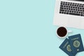 Flat lay of two passport , coffee cup and computer laptop on pastel blue color background with copy space. travel , visa