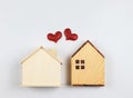 flat lay of two wooden model houses with red glitter hearts on white background. dream house , home of love, strong relationship