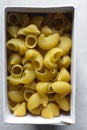 Flat lay of uncooked pipe rigate pasta in a box, top view of pipe rigate pasta shells