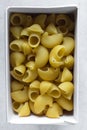 Flat lay of uncooked pipe rigate pasta in a box, top view of pipe rigate pasta shells