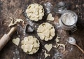 Flat lay Valentine`s day baking background. Raw apple tartlets in the baking dish and baking ingredients on wooden background