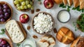 A flat lay of various breakfast foods, including cheese, bread, fruit, and dairy products