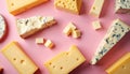 Flat lay of various cheese types spread on pink backdrop. Includes blocks, slices of hard, soft cheeses with distinct textures, Royalty Free Stock Photo