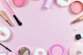 Flat lay with various makeup beauty products like brushes, powder or lipstick surrounding pastel pink background with copy space Royalty Free Stock Photo