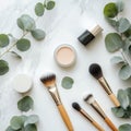 Beautiful arrangement of makeup products with brushes and eucalyptus leaves on marble surface Royalty Free Stock Photo