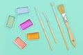 Flat lay with various metallic colorful watercolors and used dirty paint brushes on  green background Royalty Free Stock Photo