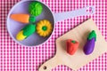 Flat lay of various vegetables in pan and on cutting board abstract against red classic checkered tablecloth texture. Royalty Free Stock Photo