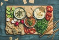 Flat-lay of Vegetarian dips hummus, babaganush, muhammara on wooden board Royalty Free Stock Photo