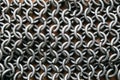 Flat lay view of chain mail armor on brown leather. Royalty Free Stock Photo