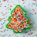 Flat lay view of Christmas tree shaped cookie cutter filled with rainbow sugar sprinkles. Royalty Free Stock Photo