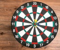 Flat lay view of a dartboard with three darts in the bull`s eye. Well-aimed dart throwing. Royalty Free Stock Photo