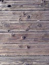 Gnarled, worn wood on a boardwalk by a lake