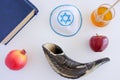 Flat lay view of Shofar, Torah book, Kippa, apple, honey and Pom
