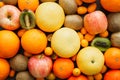 Flat lay view of various colorful fresh fruits with water drops covering background.