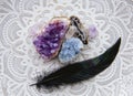 Flat lay view of various crystal geodes amethyst  celestite. With black glowing bird feather. Royalty Free Stock Photo