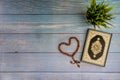 Flat lay view of vase, tasbih or rosary beads and Holy book of Al Quran