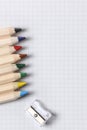 Flat lay view of white notebook , color pencils and pencil sharpener on a table. Preparing for a school. Royalty Free Stock Photo