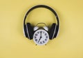 Flat lay of vintage alarm clock show 7 o`clock cover with headphones on yellow background ,time to listen to music concept or