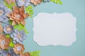 Flat lay of vintage card frame, color paper flowers design on blue background. Top view, copy space, floral art