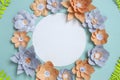 Flat lay of vintage round card frame, color paper flowers design on blue background. Top view, copy space, floral artFlat lay of v Royalty Free Stock Photo